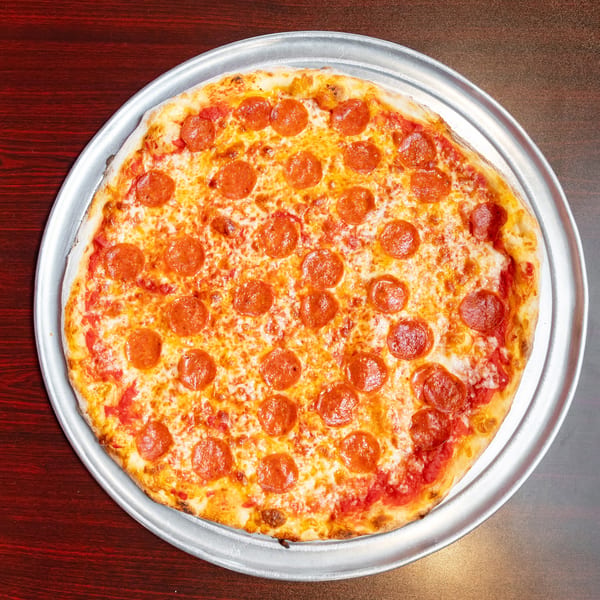 A whole pepperoni pizza with melted cheese and tomato sauce on a metal tray.